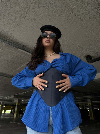 Low angle styling of blue long leather underbust corset belt