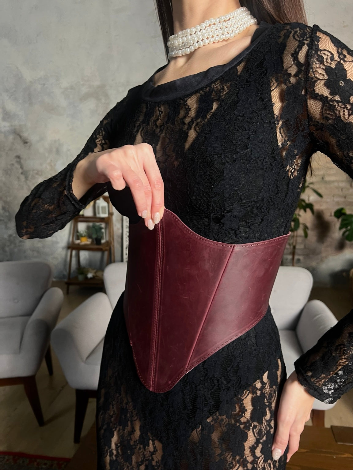 Close detail of burgundy long leather underbust corset over black lace